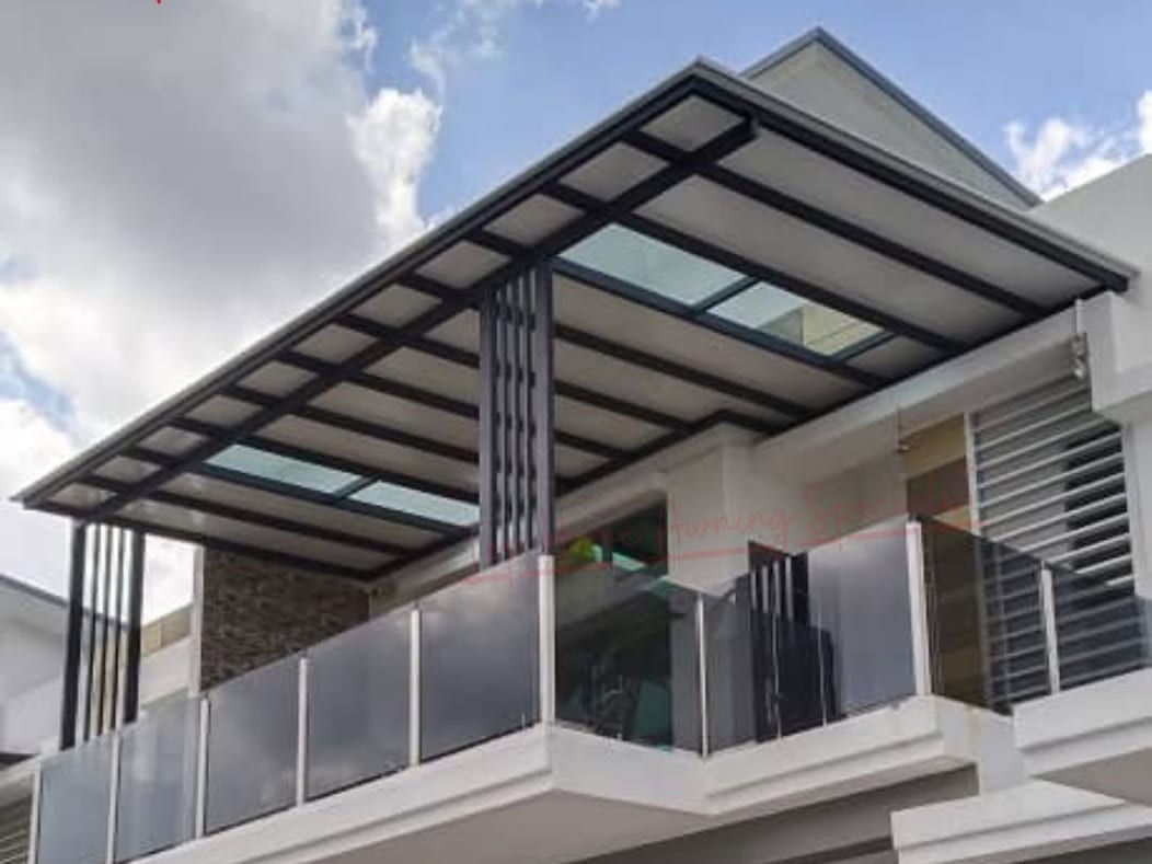 A glass roof on a black steel frame cantilevered from the front of a two-storey terrace house, below a first-floor balcony.
